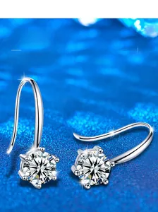 Macro detail of S925 sterling silver classic six-prong earrings on blue background