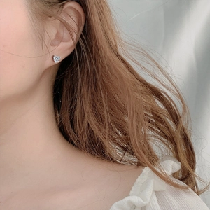 Elegant 925 sterling silver heart-shaped stud earrings with clear moissanite on model