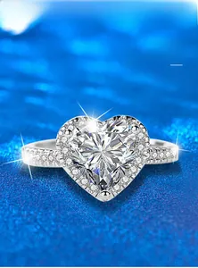 Macro shot of a heart-shaped moissanite ring with a halo setting on a blue texture