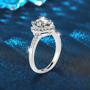 925 sterling silver halo ring with round center stone and side diamonds on blue background