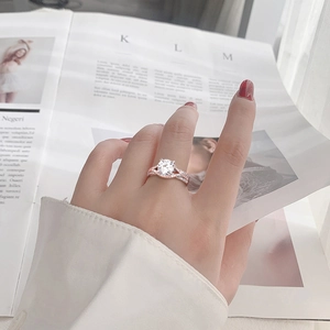 Exquisite rose gold moissanite ring set with sparkling round diamonds worn on hand