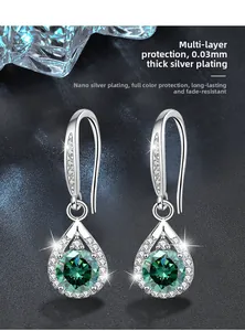 Detail of drop-shaped earrings featuring green stone and silver-plated finish