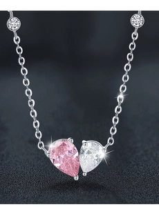 Macro shot of 925 silver heart necklace with pear-cut pink and white zircon stones