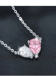 Macro close-up of 925 silver heart necklace featuring pink and white pear-cut zircons