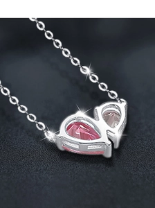 Close-up of 925 silver necklace with heart-shaped pink cubic zirconia pendant
