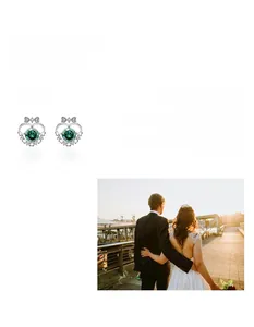 Detailed close-up of 925 sterling silver heart bow earrings with green moissanite stone