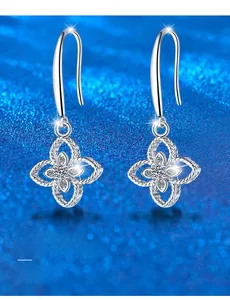 Macro detail of silver four-leaf clover earrings with 3EX cut moissanite stones