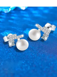 Macro detail of S925 silver pearl earrings with paved zircon stones and blue bokeh light