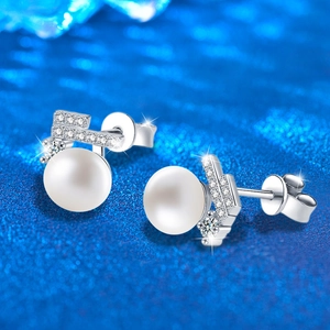 925 silver pearl stud earrings with sparkling stones on a blue textured background