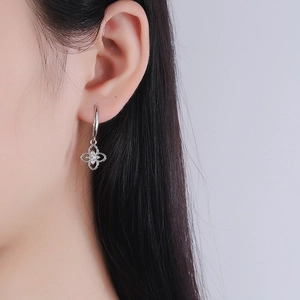 Elegant 925 sterling silver four-leaf clover drop earrings worn by a model in profile