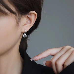 Elegant 925 sterling silver snowflake hoop earrings with sparkling moissanite on model