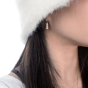 Boucles d'oreilles en argent 925 et moissanite avec trois pierres sur un mannequin