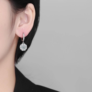 Sparkling S925 silver sunflower moissanite drop earrings worn by a model in a close-up view