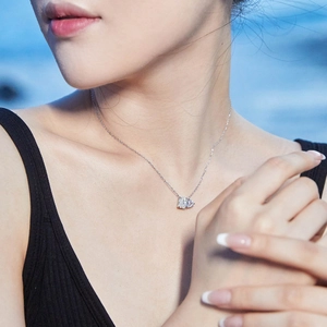 Moissanite 925 silver necklace with emerald and pear cut pendant on a model