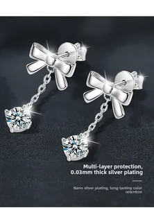 Close-up of 925 silver bow earrings with sparkling zircon drop and tassel detail