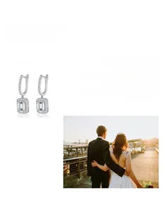 Macro detail of radiant cut moissanite earrings with halo design in 925 silver