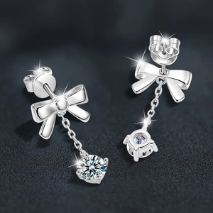 Elegant 925 sterling silver bow earrings with round zircon tassels on leather background