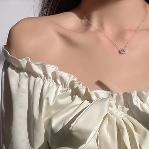 Élégant collier en moissanite or rose avec pendentif halo rond porté sur de la soie blanche