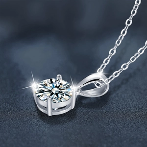 Classic 925 sterling silver four-prong moissanite pendant necklace on dark background
