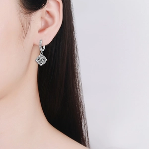 925 silver windmill drop earrings with moissanite center stone worn by a model