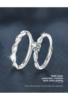 Detail of twisted s925 silver couple rings featuring a sparkling moissanite stone