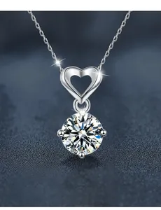 Vue macro d'un pendentif cœur en moissanite 1ct en argent S925 sur socle bleu foncé