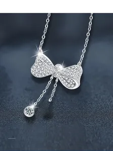 Macro detail of S925 sterling silver bow pendant necklace featuring pavé moissanite stones