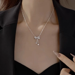 Moissanite bow tassel necklace in S925 sterling silver worn on model with black outfit