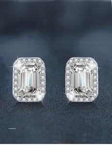 Macro detail of emerald cut moissanite earrings with 3EX grade halo setting in 925 silver