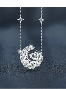 Détail macro du pendentif lune et cœur en argent avec étoiles sur cuir bleu texturé