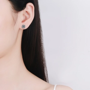 S925 sterling silver windmill stud earrings with moissanite on a model's ear