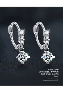 Detail of silver drop earrings with triple stones and large round moissanite pendant