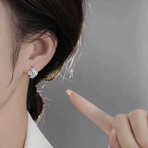 Elegant S925 sterling silver four-leaf clover earrings with sparkling moissanite on model