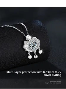 Macro detail of silver Ruyi lock pendant with sparkling stones on black jewelry roll