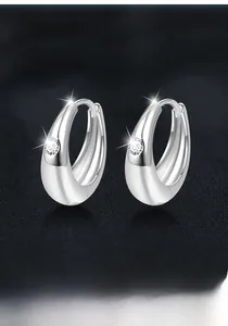 Dettaglio macro di orecchini a cerchio in argento S925 con moissanite lucidata