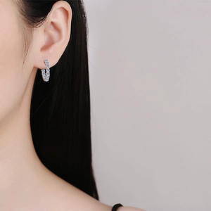 Élégantes boucles d'oreilles créoles moissanite en argent 925 portées par un mannequin