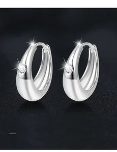 Dettaglio macro di orecchini huggie in argento S925 con moissanite taglio tondo 3EX