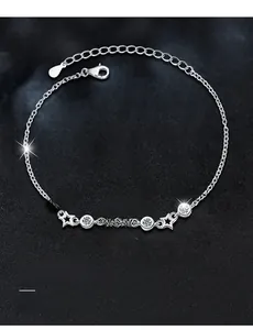 Detailed view of silver bracelet featuring 3EX cut moissanite with 58 facets and star charms