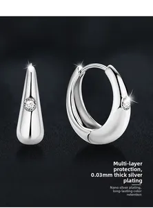 Dettaglio macro di orecchini a cerchio in argento S925 con design a goccia lucido