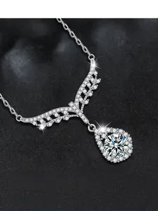 Macro shot of S925 silver angel wing necklace with sparkling teardrop moissanite pendant