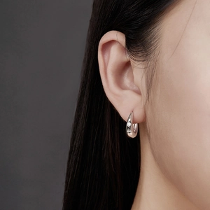 Eleganti orecchini huggie in argento S925 con moissanite scintillante sulla modella