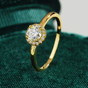18K gold plated S925 silver halo ring with round moissanite on green velvet background