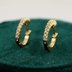 Macro shot of 18K gold plated S925 silver earrings with sparkling round moissanite rows