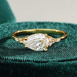 Bague en or 18 carats avec pierre poire sur un écrin de bijoux en velours vert