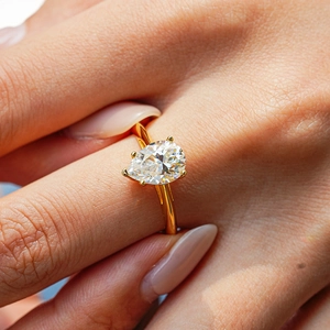 Pear-shaped moissanite ring with 18K gold-plated S925 silver band on a model's hand