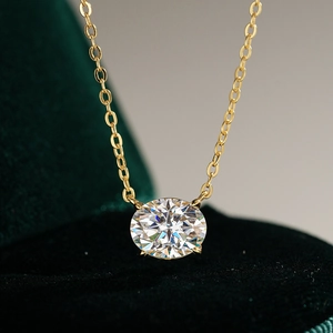 Pendentif moissanite ovale en argent 925 plaqué or 14K sur fond de velours vert