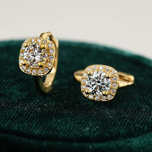 Elegant gold square halo moissanite earrings on dark green velvet display