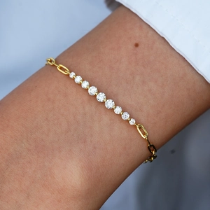 Détail d'un bracelet en or orné de neuf pierres de moissanite dégradées porté au poignet