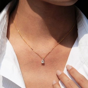 Elegant 14K gold plated pear cut moissanite necklace worn by model on white shirt