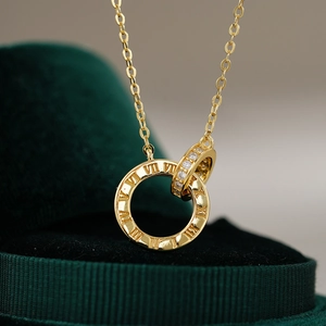 Macro detail of 14K gold plated Roman numeral interlocking ring pendant with white zircons